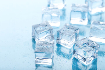 Ice cubes with water drops on blue background