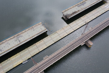 Damaged road bridge across the river. Drone view.