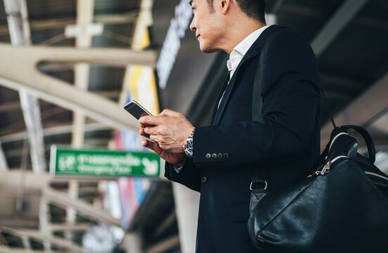 Business man using phone and waiting at the skytrain station stock photo