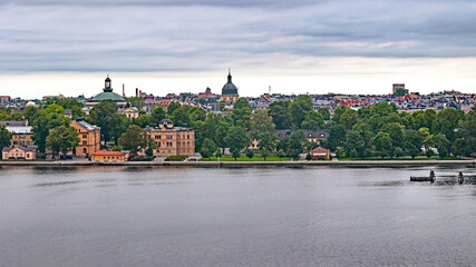 Panoramic view of different parts of Stockholm from the observation deck, cloudy summer day with blurry small fragments in the corners of the card