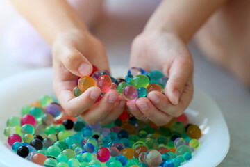 Children is hands are holding the orbeez.