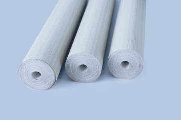 Three rolls of gray paper wallpaper  wall renovation. Gray background.
