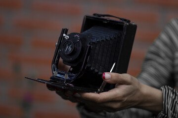 Old German retro camera in the hands of a young girl photographer