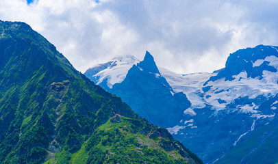 Fototapeta premium Beautiful landscape of glacier in summer season. Glacier mountain with green vegetation on high ground in cloudy weather.