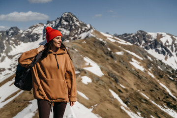 Naklejka premium young girl in the mountains with a backpack. Active rest in one with nature
