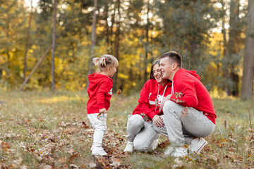 Fototapeta premium dad, mom and little cute daughter having fun and playing in the autumn park. family concept, father's, mother's and baby's day