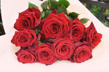 Red large roses on a white background. A bouquet of fresh flowers. A romantic gift.