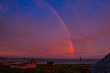 Night rainbow in the abandoned Tobseda village in Barents Sea coastal area, Russia