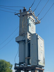 Old and rusty transformer station in summer on a clear day against the blue sky close up