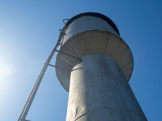 bottom view of an Old metal water tower on a Sunny day in the Russian countryside in summer.