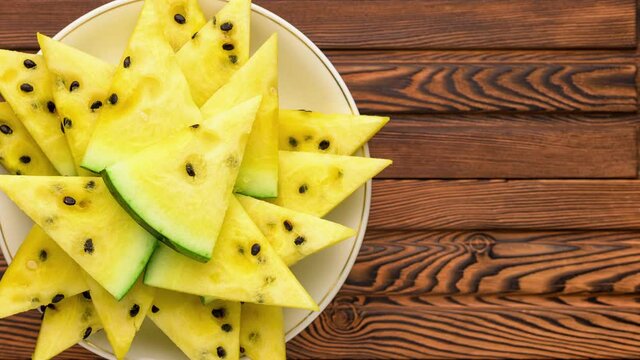 Closeup of fresh yellow watermelon slices on white plate