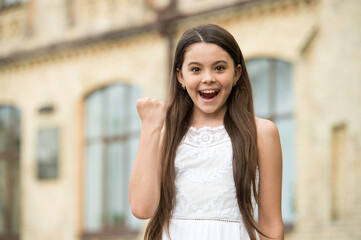 Fototapeta premium Happy child long hair smiling face urban background outdoors, successful day concept