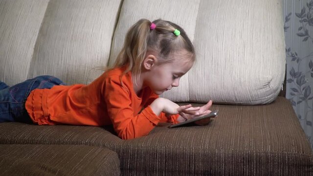 little girl draws a finger on phone