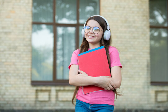 Girls Deserve The World. Get Knowledge From Ebook. Modern School Education. Back To School. Happy Teen Carry Workbook. Smiling Kid Hold Folders. Childhood Happiness. Girl In Headset Listen Music