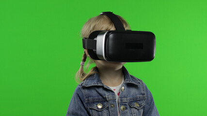 Child girl using VR headset helmet to play game. Watching virtual reality 3d 360 video. Chroma key
