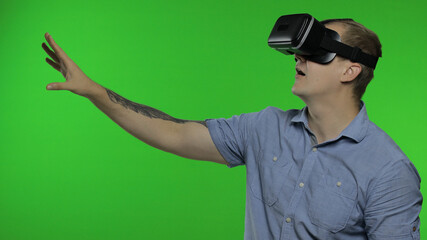 Man using VR app helmet to play simulation game, drawing. Guy watching virtual reality 3d video