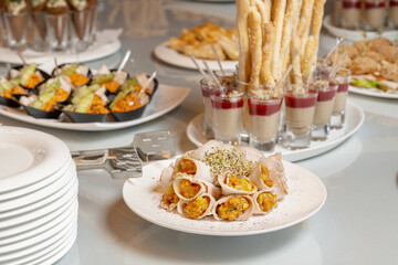 Bacon rolls with delicious filling and sprouted grains. Laid out on a white plate.