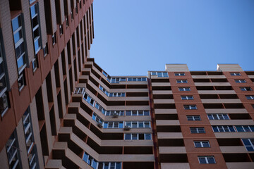 Fototapeta na wymiar facade of a tall brick apartment building. Construction and real estate.