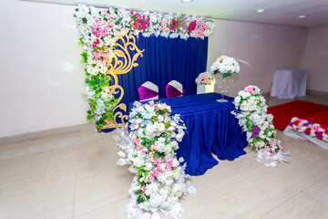 Artificial colorful paper flowers with navy-blue color based wedding stage decoration.