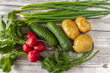 Assorted fresh vegetables: potatoes, cucumbers, green onions, dill, radishes.