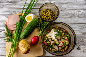 Vegetable cold soup in a plate and ingredients on a cutting board. Close-up.