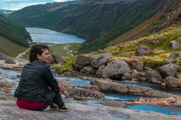 Woman sitting on the hill, Glendalough Valley, Ireland.