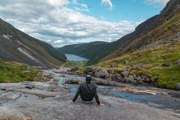 Man is looking at the Glendalough Valley.