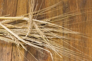 Close up view of wheat ears on brown wooden background isolated. Agriculture. Organic. Food. 