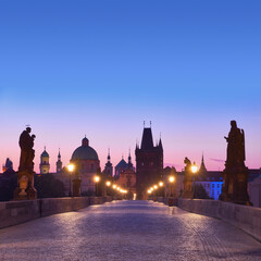 Fototapeta premium Most Karola o świcie, sylwetka Bridge Tower i rzeźby świętych z latarniami ulicznymi w Pradze, Czechy