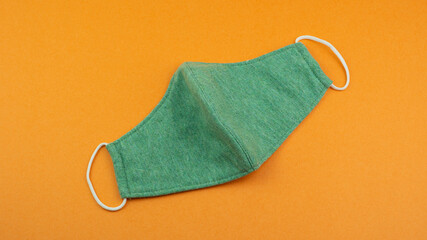 Protective non medical face mask rotation, New Normal social concept, on orange background. ...