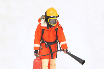 A portrait of Asian male firefighter in orange protective uniform, mask and helmet with fire extinguisher standing on white background.