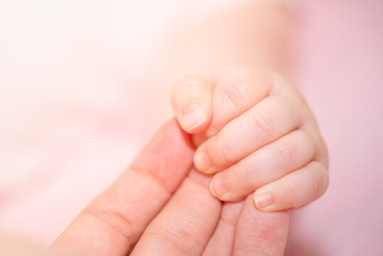 Newborn baby holding mother's hand, image with shallow depth of field