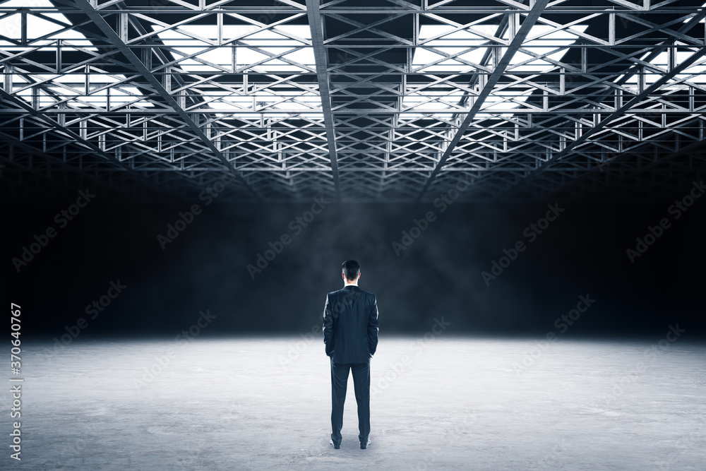 Wall mural businessman standing in showroom with metal structure on ceiling.