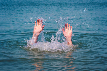 Hands of a drowning man above water in need of help