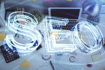 Double exposure of SEO drawing over study table background with computer. Concept of search. Top view.