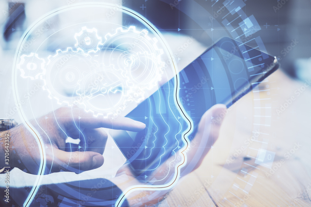 Poster Hands using tablet computer and glowing head with cogs hologram