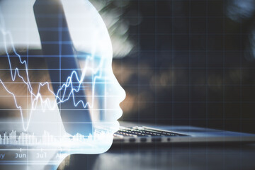 Laptop computer with glowing head with forex chart interface.