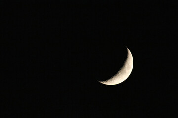 Sliver of moon in dark night sky