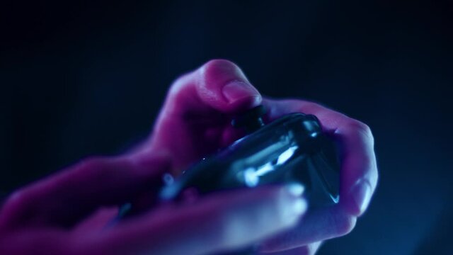 Playing video games in a darkened room with a black background close up on a controller joystick playing quikly blue lens flare