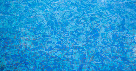 A pool with a mosaic bottom. Blue transparent water ripples. Space for text