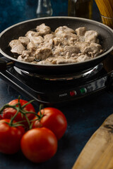 Fresh pork meat in a pan fried on a background of vegetables