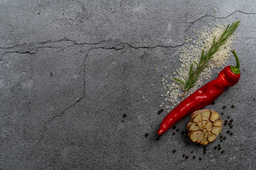 One red chili pepper, lying on the right side with copy-space. Black, dark grey background