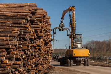 Industrial loader loads logs at a sawmill