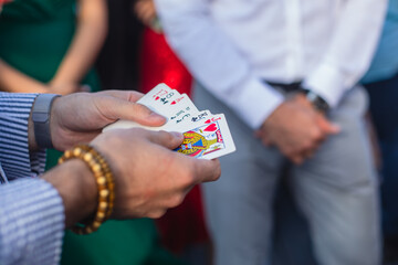 Magician showing card tricks focus in front of guests on party event wedding celebration, juggler...