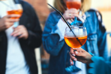 Row line of red colored negroni and spritz aperitif alcohol cocktails on a party of alcohol setting on catering banquet table, vodka, and others on decorated catering table event with bartender