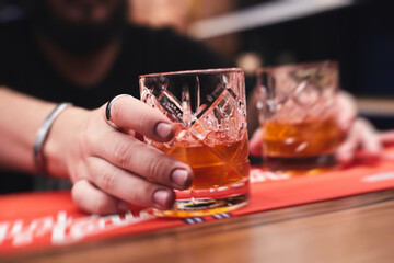 Row line of red colored negroni and spritz aperitif alcohol cocktails on a party of alcohol setting on catering banquet table, vodka, and others on decorated catering table event with bartender