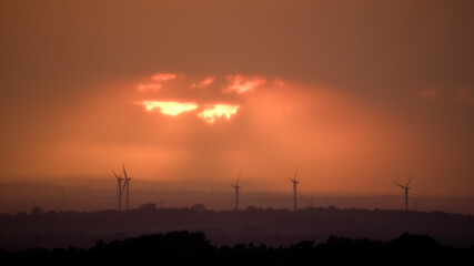 Sunset with wind turbines and dark orange sky, UK