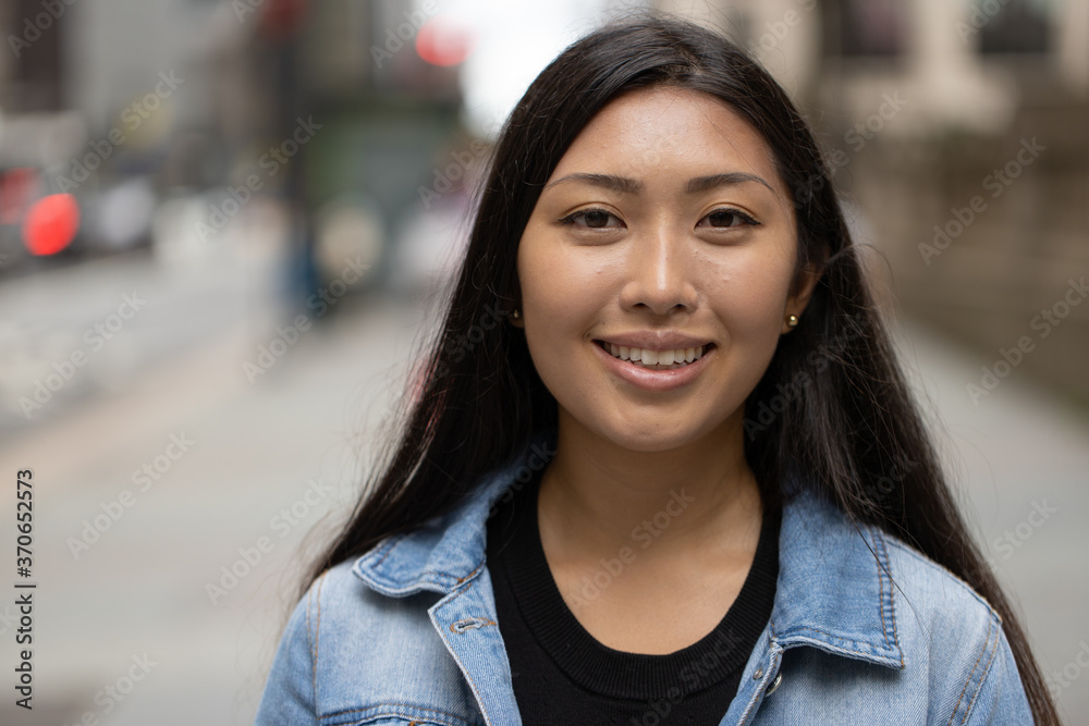 Wall mural young asian woman smile happy face portrait in city