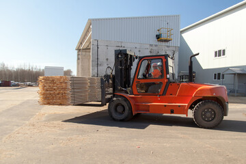 Industrial loader moves boards on a sawmill