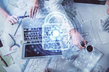 Double exposure of man and woman working together and technology theme lock drawing hologram. Security concept. Computer background.